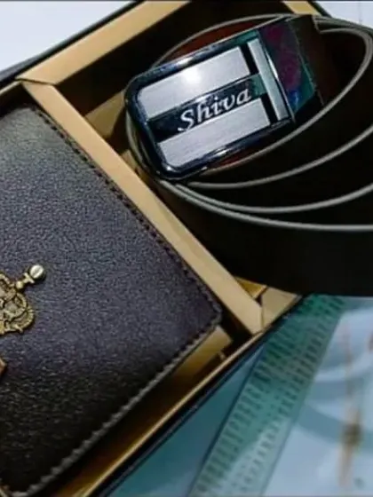 This combo set features a personalized brown leather wallet with a crown charm and a matching leather belt with the name engraved on the buckle.