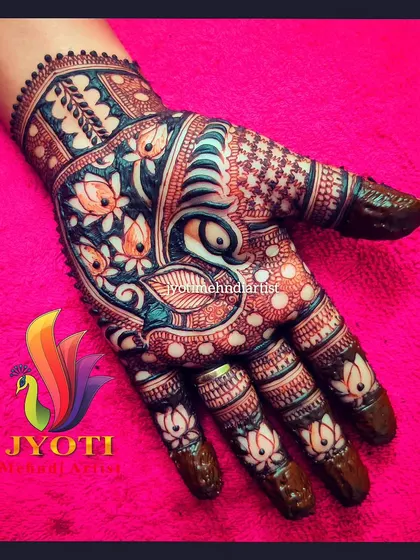 A vibrant and colorful Indian mehndi design, featuring a peacock and lotus flowers. The use of negative space makes the motifs stand out beautifully.