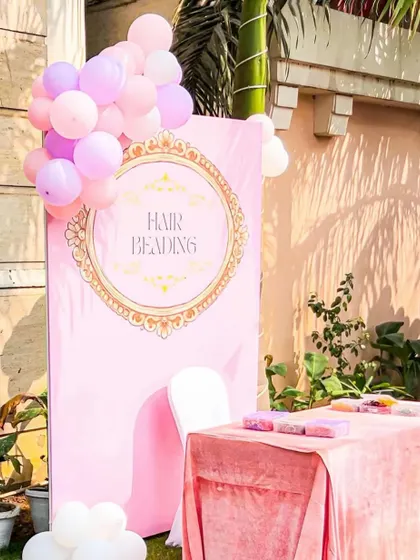 The charming hair beading station, set up outdoors. The pink decor and balloon accents create a fun and pretty corner for little princesses to get pampered.