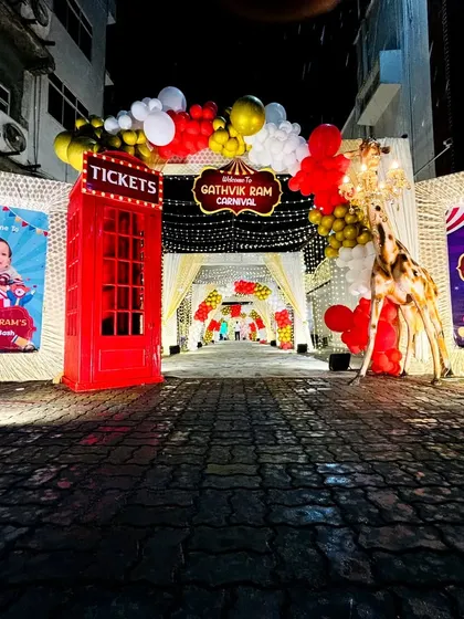 The full view of the carnival entrance, complete with personalized welcome signs on either side of the balloon-decorated walkway.