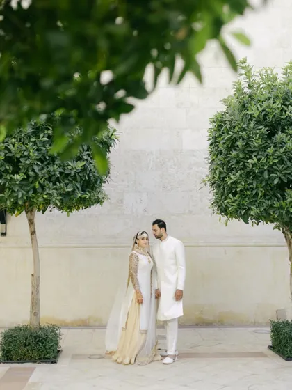 A beautifully symmetric portrait of Moin and Roha, framed by two trees. This shot highlights the serene and thoughtful design of the venue.