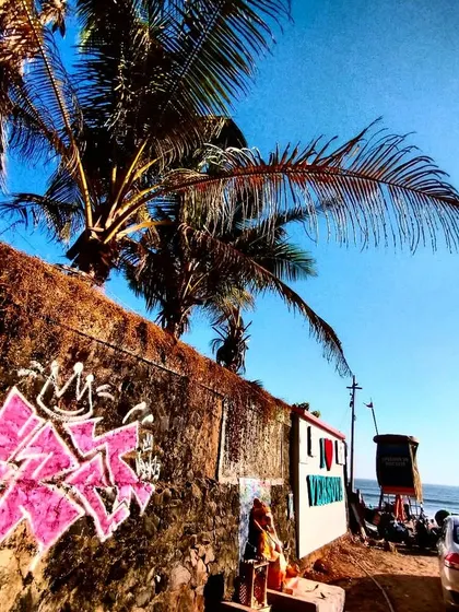 A close-up of the pink graffiti piece, showing the sharp angles and spray-can textures against the rough wall.
