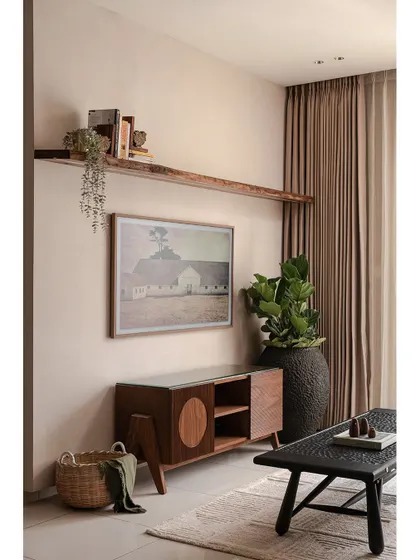This sleek TV console defines the living area in 'Kayu'. While the space exudes minimalism, the textural qualities of each furniture piece, like the carved coffee table and woven basket, add layers of visual interest and warmth.