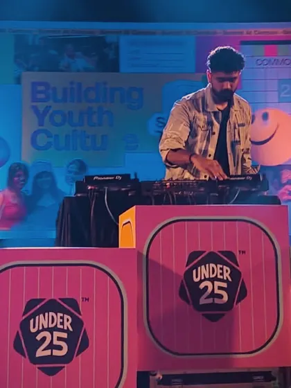 At the decks during the Under 25 Summit at IIM Kozhikode, with the event's vibrant branding in the background. I ensure my performance setup integrates seamlessly with the event's theme.
