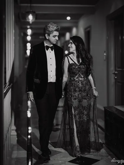 A classic black and white portrait of the couple walking hand-in-hand before their cocktail party. Timeless elegance.