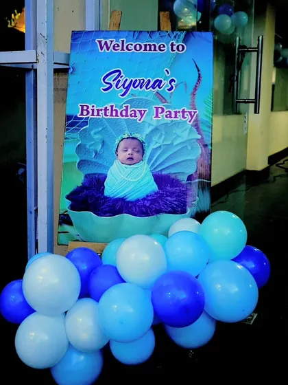 A personalized welcome sign for Siyona's Moana-themed birthday party, featuring a beautiful image of the baby in a clamshell.