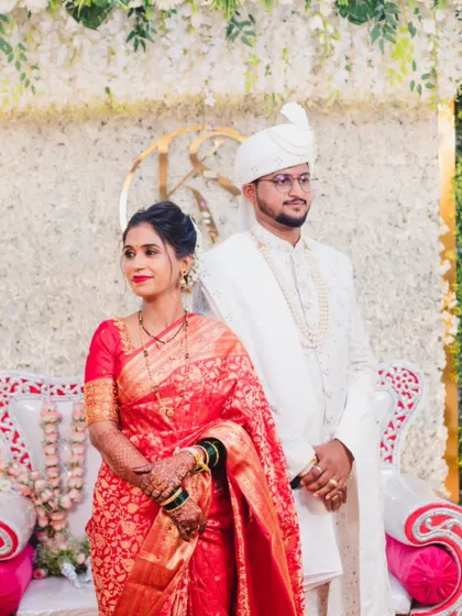 A formal portrait of the bride and groom, showcasing their traditional Maharashtrian wedding attire in full.
