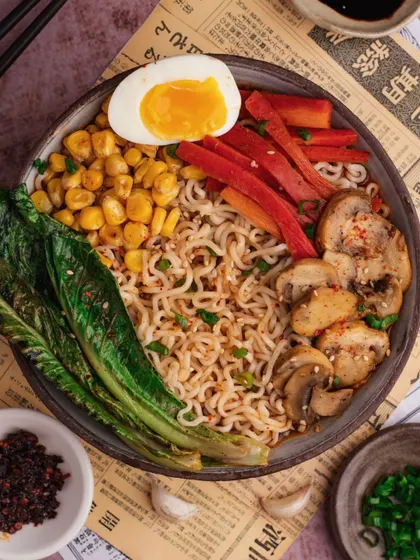 A comforting bowl of ramen, styled and shot by our team. We carefully arranged the noodles, soft-boiled egg, mushrooms, and corn to create a visually appealing and satisfying meal that looks ready to eat.