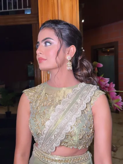 A side profile, giving a great view of the intricate earrings and her elegant hairstyle.