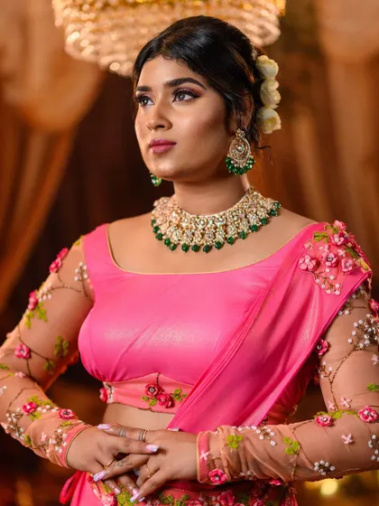 A detailed close-up focusing on the retro-inspired makeup, with winged eyeliner and soft pink tones. It also provides a clear look at the emerald and pearl necklace set we chose for this look.