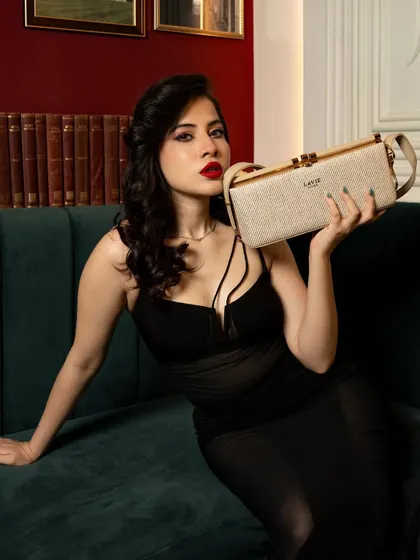 A commercial product-focused shoot for Lavie handbags featuring influencer Uorfi Javed. The image balances celebrity presence with clear product visibility for a brand campaign.