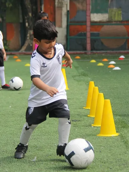 A player practices dribbling through a line of cones, a classic drill that is fundamental for developing speed and control on the ball.