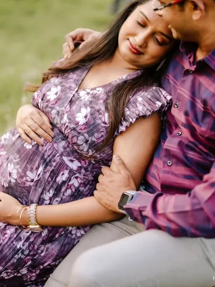 A loving embrace between an expecting couple during their outdoor maternity shoot. Their relaxed and happy expressions show their excitement for the journey ahead.