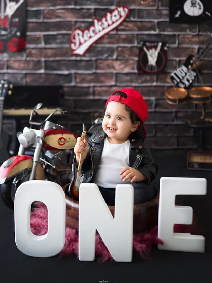 A cool little rockstar posing with the letters O-N-E for his first birthday.