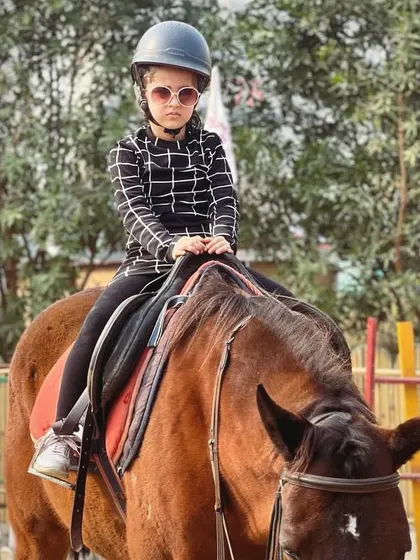 A stylish young rider looking cool and composed on her horse. We welcome kids to express their personality while they learn to ride.