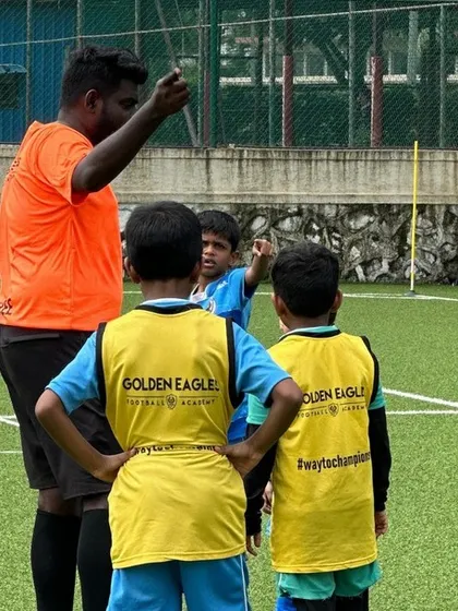 A coach gives instructions to our younger players. Clear communication and guidance are central to our coaching philosophy, ensuring every child understands the drill.
