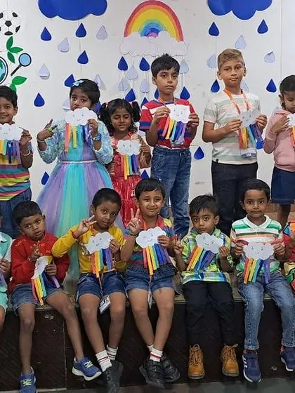 Students of different ages come together on stage to display their rainbow creations.