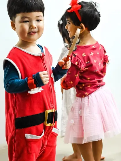 Two children in their Christmas outfits share a moment during the party.