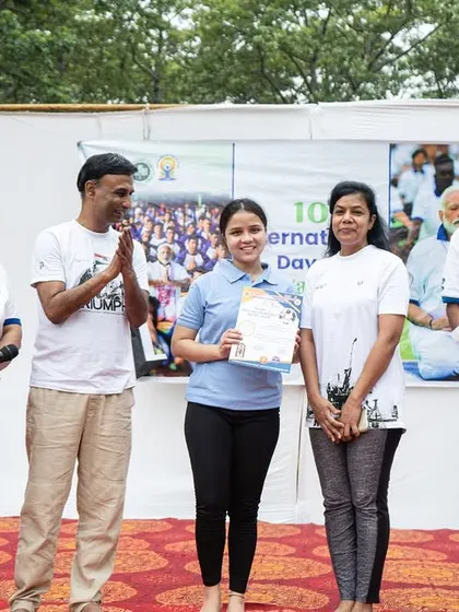 A student receiving her certificate on stage, a moment of recognition for her participation and skill.