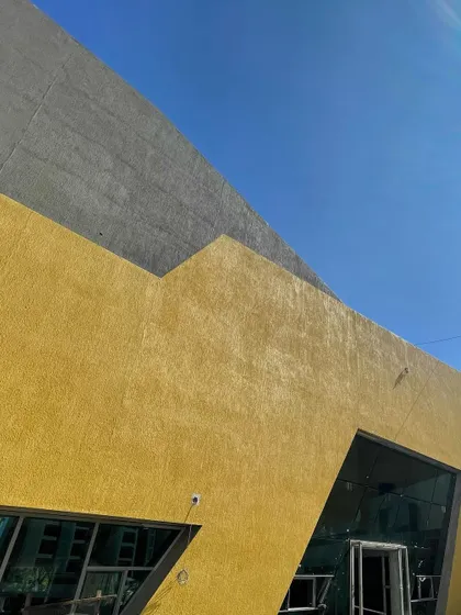Detail of the facade junction between the yellow and grey textured surfaces at brigade utopia.