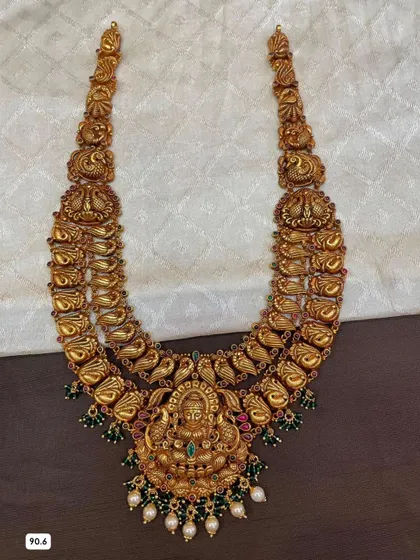 A magnificent double-layered haram crafted from 92.5 silver with gold plating. The design includes peacock and floral motifs, finished with green stones and pearls.