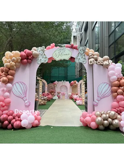 A stunning pink archway welcoming guests to a Ralph Lauren-inspired girly birthday party. The entrance is decorated with an elaborate balloon garland in shades of pink and rose gold, setting a chic and celebratory mood.
