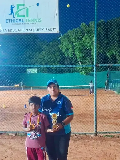 A player and coach pose with their trophies on our floodlit clay court at the Saket center. This photo shows that our matches can continue well past sunset, thanks to our excellent facilities.