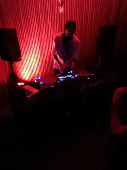 A full view of my DJ booth during a throwback set. I enjoy the simplicity of a dark room, good speakers, and a crowd that's ready to vibe.