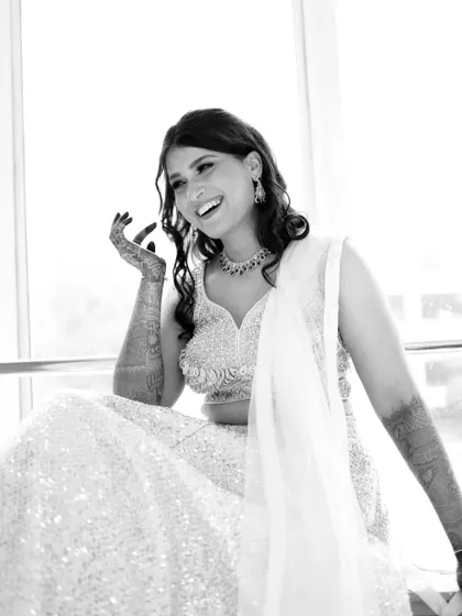 A bright, high-key black and white portrait of a bride, her laughter infectious and joyful.