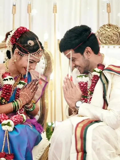 A traditional greeting, a shared smile. This moment during the ceremony is full of respect and joy, beautifully captured in a symmetrical and elegant composition.