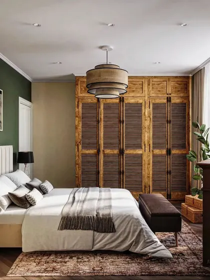 To evoke a year-round summer feeling, we designed this bedroom with tropical-inspired elements. Louvered wooden wardrobe doors, natural fiber lighting, and lush indoor plants create a warm, relaxed atmosphere reminiscent of a holiday escape.