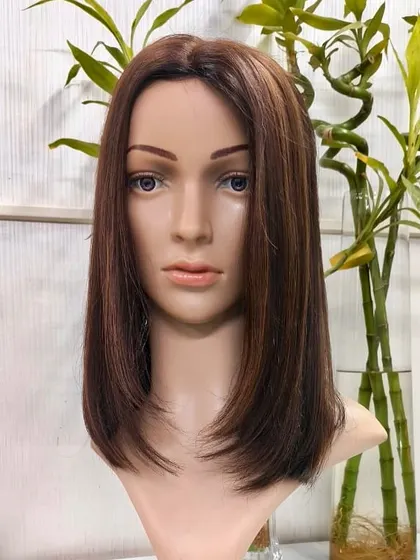 A studio shot of our Silk Base 5x7 Topper on a mannequin, showcasing its sleek style and natural appearance against a clean background.