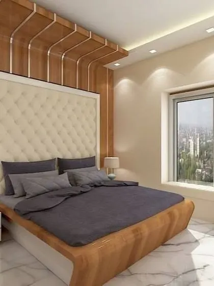 A bright and airy bedroom with a stunning view. The tufted cream headboard and wood-paneled feature wall add a touch of luxury, while the marble flooring keeps the space feeling cool and elegant.