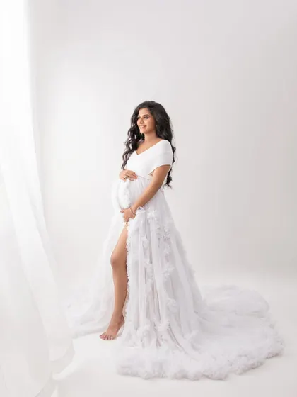 A standing pose that shows off the beautiful slit and flow of the white gown. The sheer curtains add a layer of softness to the image.