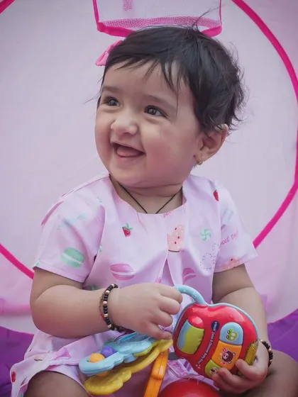 Happiness is a choice, and this baby's smile is infectious. A simple, happy portrait of a baby enjoying playtime with a colorful toy.