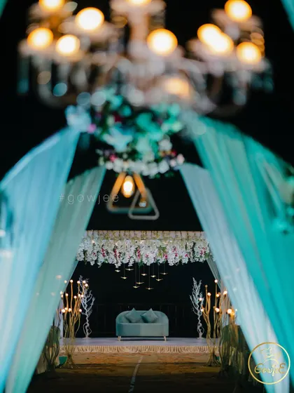 A beautifully blurred shot focusing on the chandelier, with the elegant pastel stage in the background.
