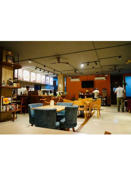A wide view of the main cafe area, showing the mix of comfortable seating, the counter where the magic happens, and the overall spacious and airy feel of the place.