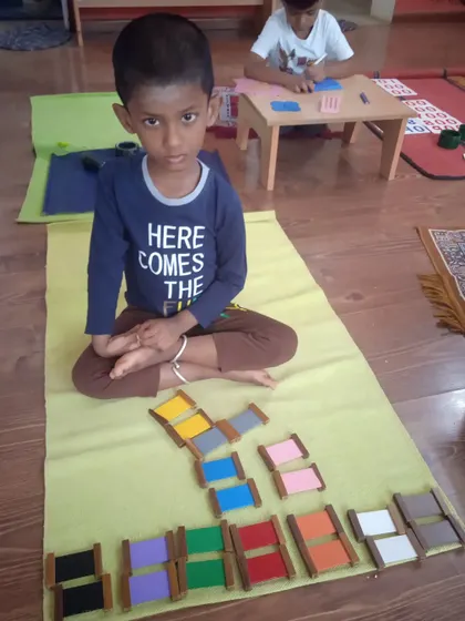 The Colour Tablets refine a child's perception of color. This child is grading tablets from darkest to lightest, an activity that trains the eye and develops an appreciation for subtle differences.