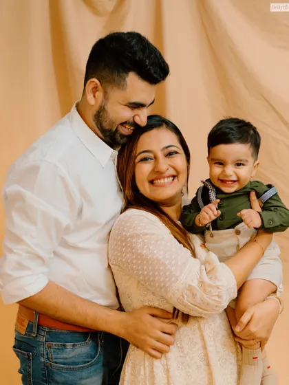 A classic family portrait, radiating warmth and happiness. The coordinated outfits and genuine smiles make this a timeless keepsake.