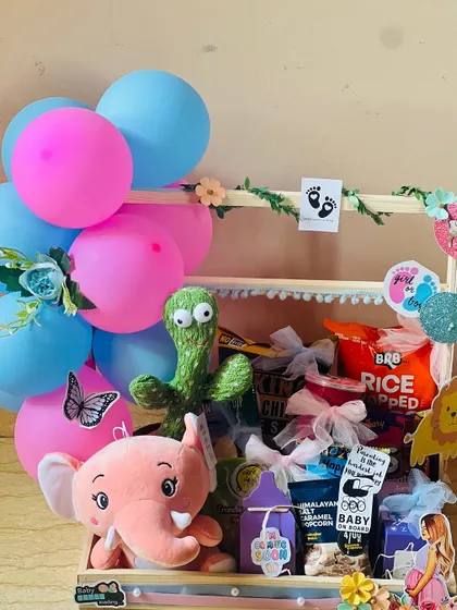 This view showcases the full arrangement of the baby shower gift hamper, with its playful toys and delicious treats ready to delight the parents-to-be.