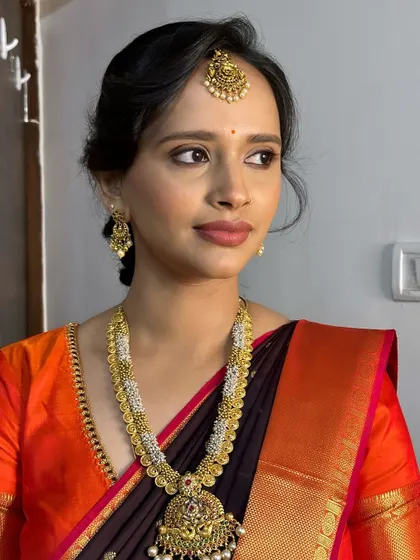 A simple yet stunning look for a wedding guest. The makeup focuses on a clean base and defined eyes, paired with a neutral lip that complements her beautiful silk saree.