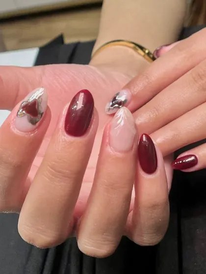 A close-up showing the detail of the sculpted, feather-like design and the abstract chrome heart.