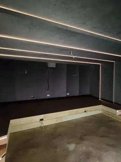 The room after the base construction and lighting installation. The linear LED lights are tested before the final flooring and furniture are brought in.