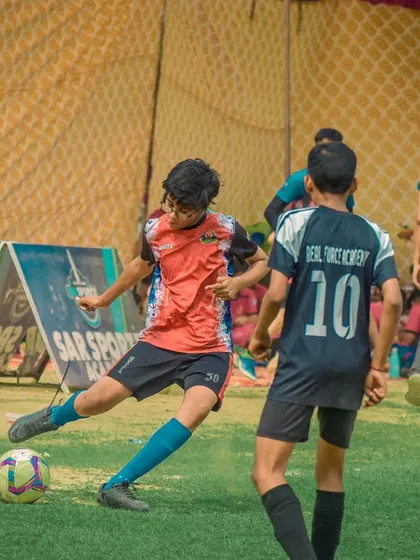 A player takes a shot while being closed down by a defender.