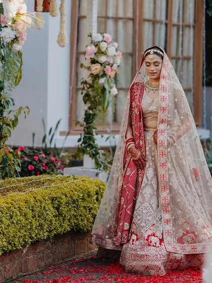 A full-length shot of the bride against the floral decor of her Ooty home. The traditional architecture and the soft flowers created a timeless look.