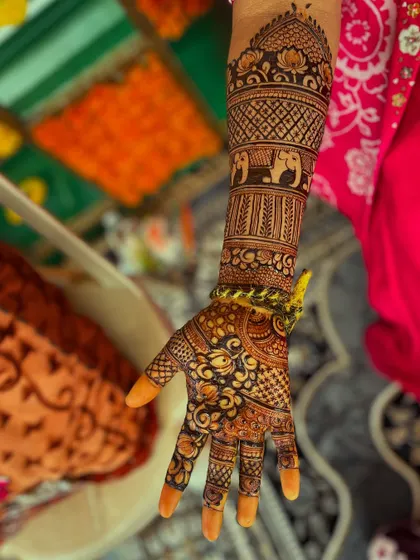 A single arm view of the traditional Hindu bridal design, highlighting the elephant band and the dome motif at the top.