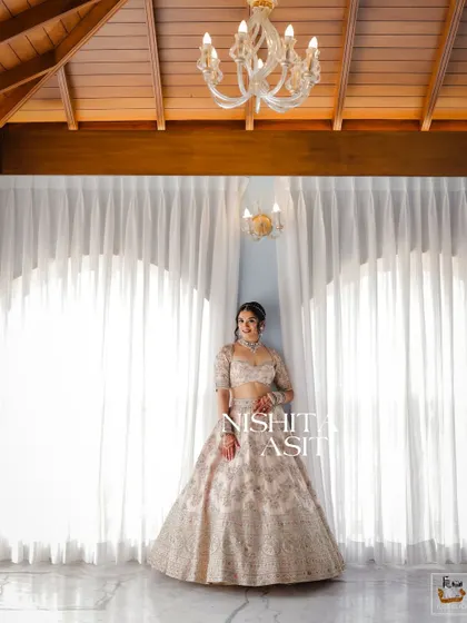 A full-length bridal portrait in a beautiful room with high ceilings and elegant curtains.