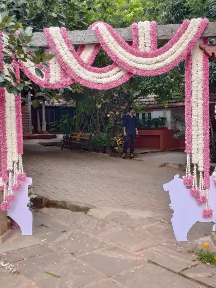 This beautiful entrance arch is decorated with thick garlands of pink and white flowers. It creates a soft and welcoming entryway for guests at a naming ceremony, baby shower, or any family function.