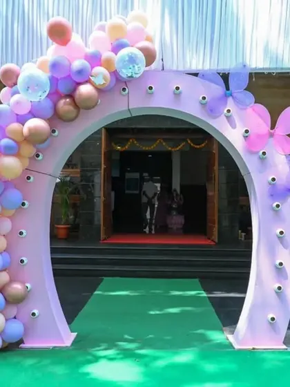 The entrance arch for a butterfly-themed party, decorated with pastel balloons and large butterfly cutouts.