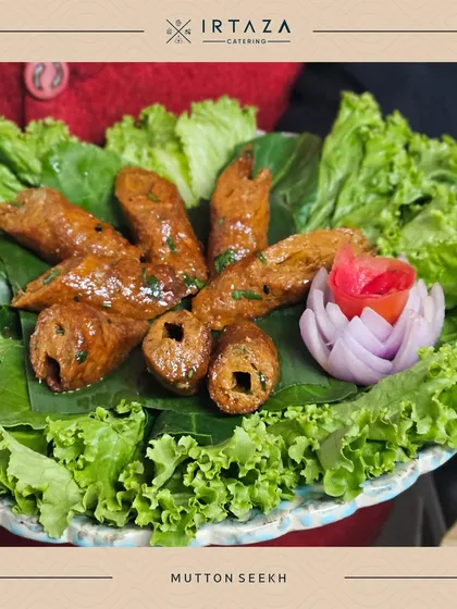 Mutton Seekh Kebabs, beautifully arranged on a bed of lettuce with a carved tomato and onion garnish. The presentation highlights the care I put into every single dish.